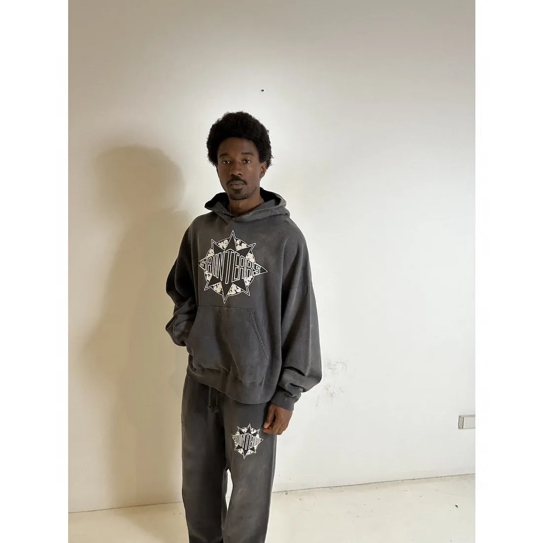 DENIM TEARS x SAINT Mxxxxxx SAINT TEARS Hoodie/BLK Five-pointed star cotton hole-in-the-dark distressed hoodie, washed black S-XL Assute dyeing, whole piece sprayed with horse fade/horse weight, co-branded main mark/cotton wash mark/cherub mark, many hanging holes on the front and rear panels, the original version has the same loose fit